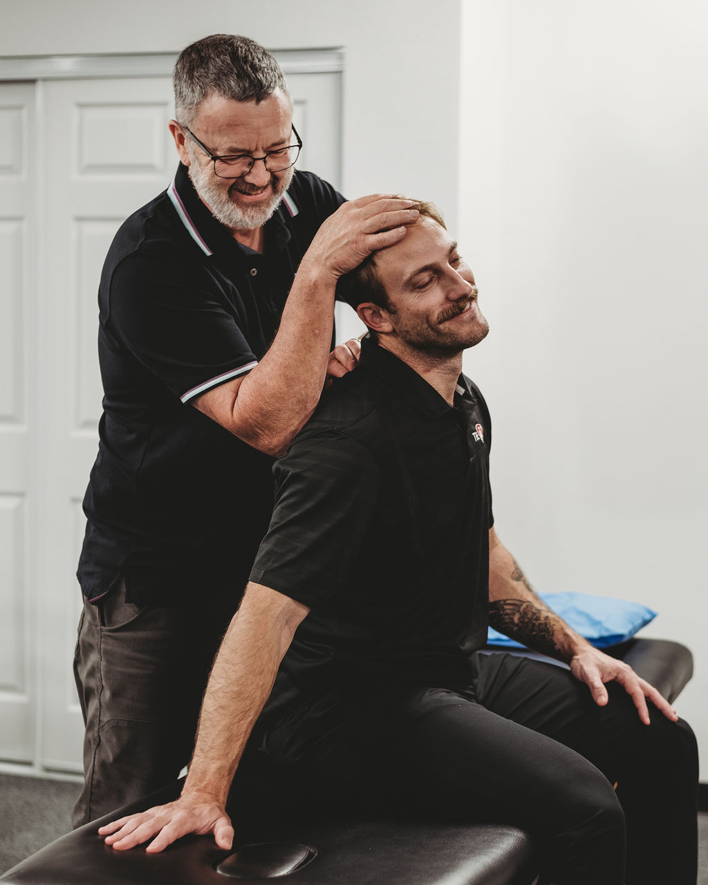 physical therapist adjusting patient in treatment room