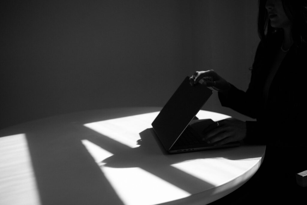 Hand closing a laptop after reviewing website traffic data and analytics